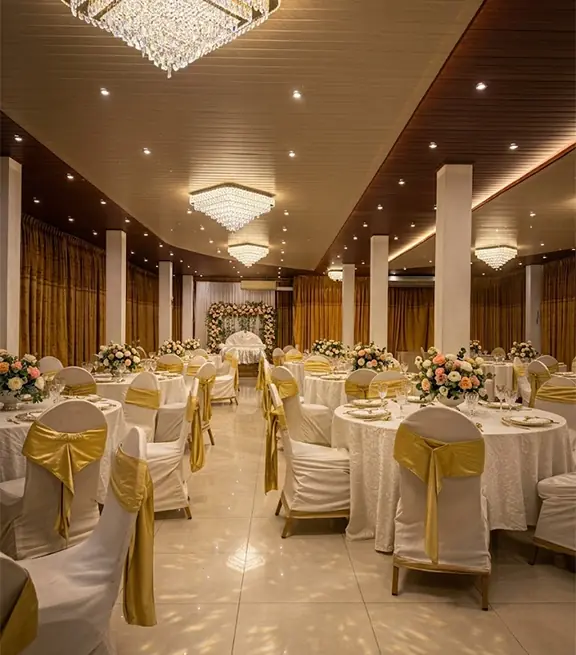 Wedding hall at Hotel Neits with chandeliers and gold-sashed chairs